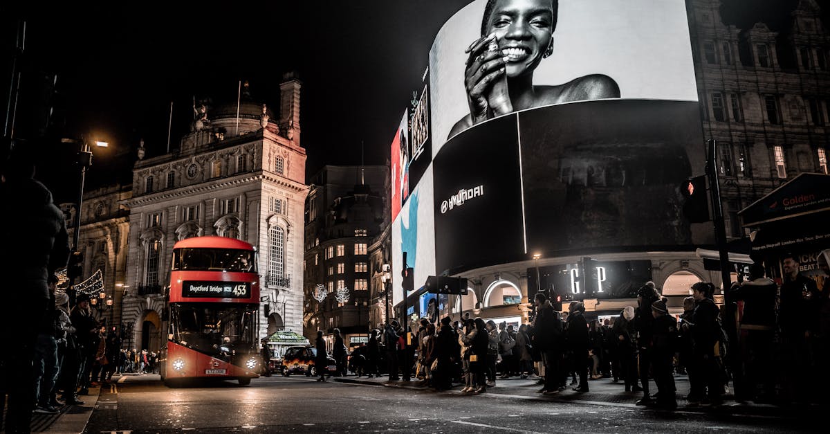 Vibrant city life at night in Piccadilly Circus, London with double-decker bus and illuminated billboards.